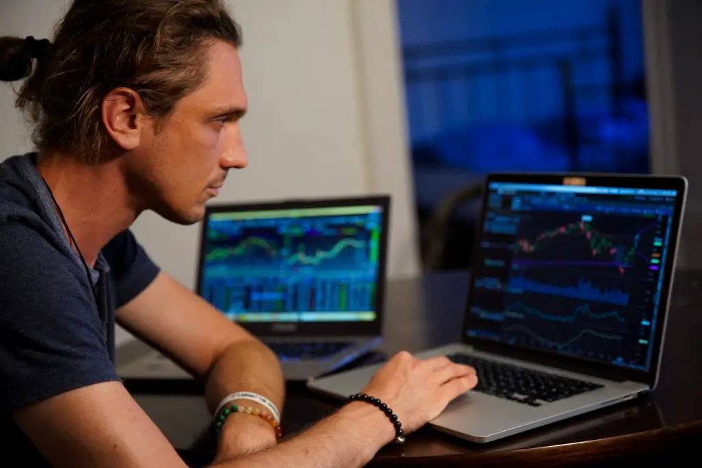 day trader staring at a laptop screen 